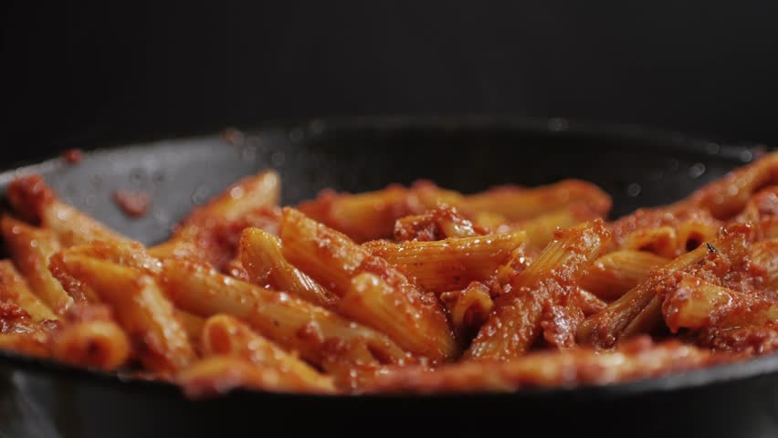 Cooking traditional arrabbiata pasta, penne with tomato sauce close-up. Cook classic homemade Italian tomato sauce for pasta and pizza in the pan. Chef cooks traditional Italian food.  | Shutterstock HD Video #1111891327
