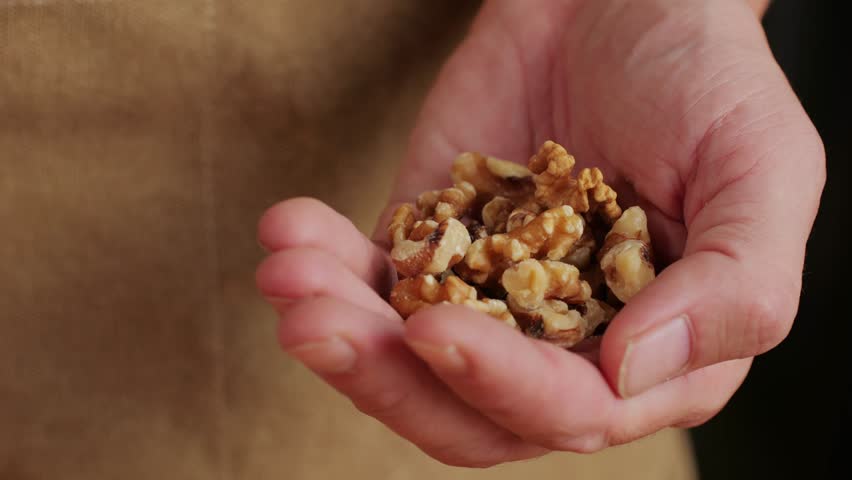 Walnuts without shell in man hand close-up macro. Peeled nuts. Healthy snacks. Product rich in minerals and vitamins. | Shutterstock HD Video #1111891343