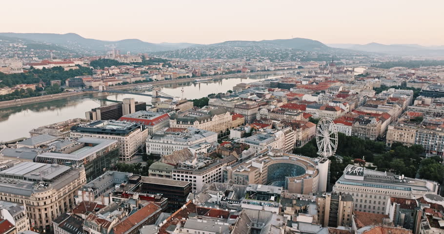 Budapest, Hungary aerial view streets old city of in summer in cloudy weather. Red roofs, lighted Ferris Wheel on Elizabeth Square, Danube River Chain Bridge of beautiful historical buildings in Buda 