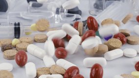 Falling Tablets and pills between glass bottles, ampoule and syringes. Slow motion. Medicine and healthy. Close up of capsules. - Powered by Shutterstock - Get 15% off with code: PIKWIZARD15