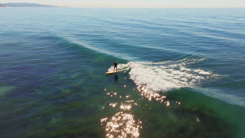Surfer Riding Blue Ocean Wave In San Diego, California, USA - aerial drone shot Royalty-Free Stock Footage #1111893939