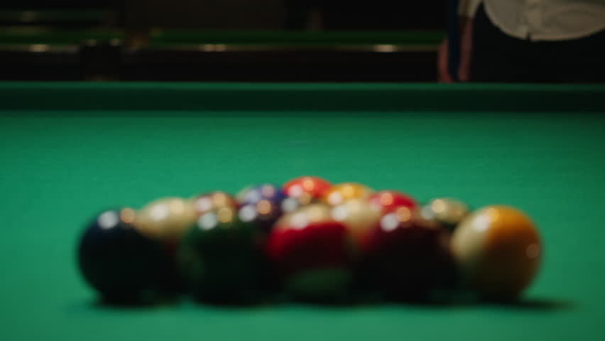 Young man breaking colorful pool balls with cue on green billiards table for start to play. American pool, poule game. Billiard balls with numbers on a pool table. Billiards team sport. | Shutterstock HD Video #1111894815