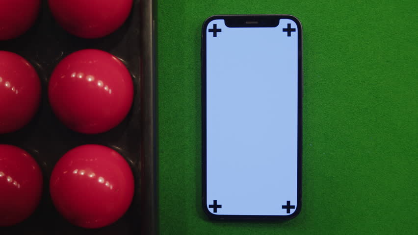 Chroma key phone on green pool billiard table among red balls. Billiard game. Smartphone with green screen | Shutterstock HD Video #1111894817