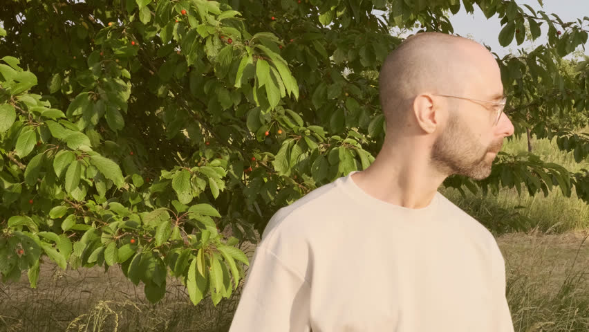 closeup young charismatic man wipes gold-rimmed glasses with napkin, checks cleanliness and transparency of lenses, concept cleaning routine, lens protection, lens care essentials, eyewear cleanliness