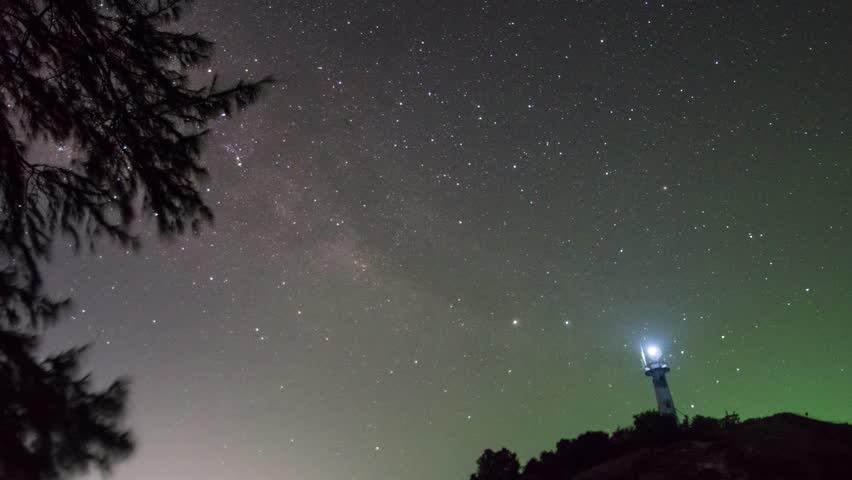 Timelapse 4k The Blurr Milky Way passes slowly until morning above the lighthouse shining at night | Shutterstock HD Video #1111903579