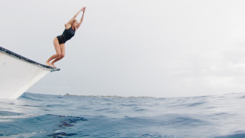 Woman jumps into the sea from a boat. Underwater view of the woman jumping into the water