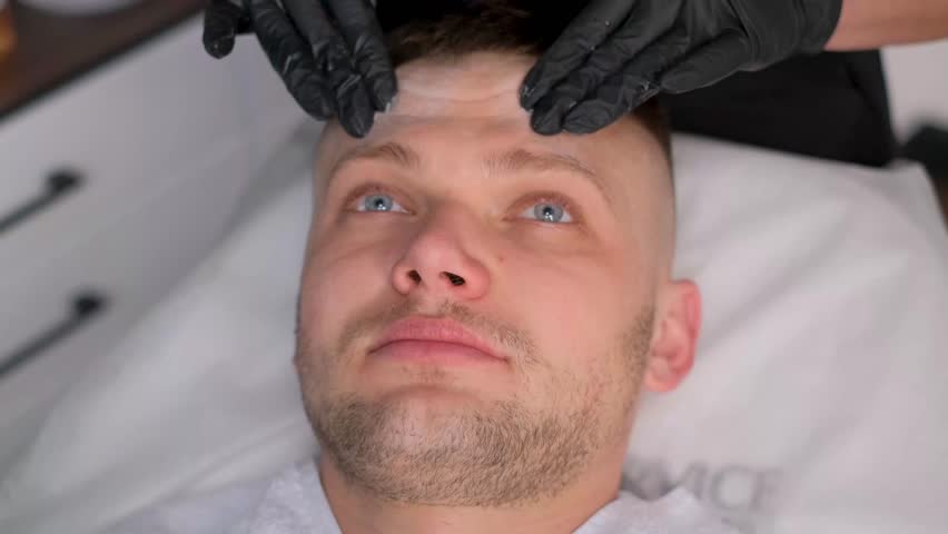 The face of a young man during a procedure in a spa salon. Facial skin cleansing. Modern spa salon | Shutterstock HD Video #1111905257