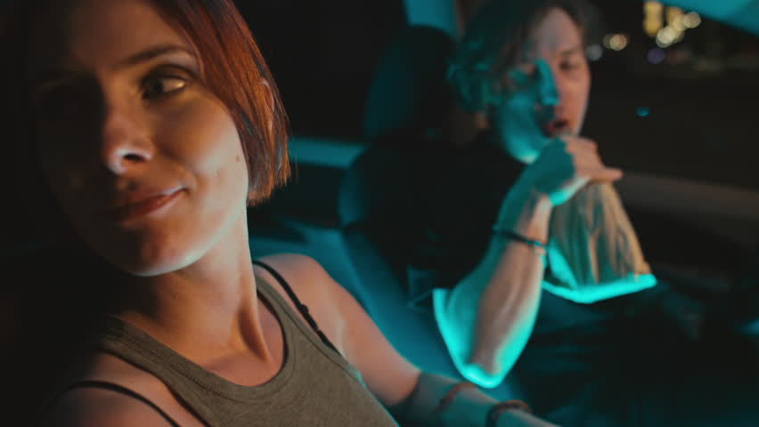 Medium side handheld shot of young smiling Caucasian woman sitting in parked car with Caucasian boyfriend drinking alcohol | Shutterstock HD Video #1111905649
