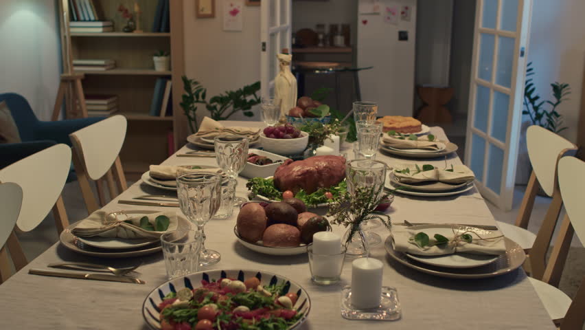 Zoom in shot of dinner table with turkey, salads, fruit and other festive dishes prepared for Thanksgiving celebration at home with cozy interior | Shutterstock HD Video #1111906313