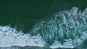 Close-up of ocean waves crashing on the shore, aerial view from drone.
