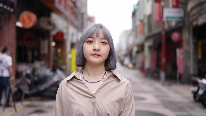 A young Taiwanese woman walking down Dihua Street, a traditional Taipei neighborhood.