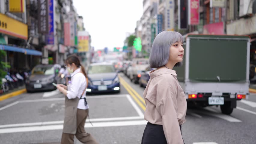 A young Taiwanese woman walking down Dihua Street, a traditional Taipei neighborhood.