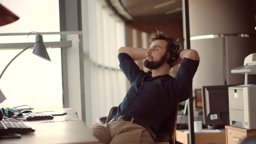 Businessman relaxing in office and listening music | Shutterstock HD Video #1111916161