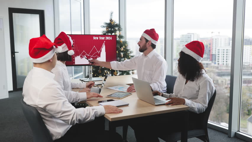 Successful team of multiethnic business people in Santa hats raising hands and screaming with happiness while working together in decorated with Christmas tree office in business center. - Powered by Shutterstock - Get 15% off with code: PIKWIZARD15