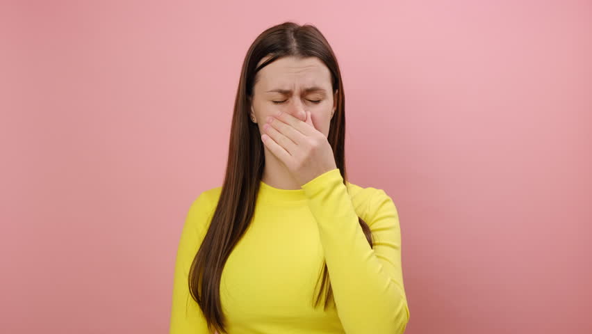 Bad smell concept. Upset young woman standing pinching her nose with fingers to hold breath, disgusted by stinky intolerable smell, wearing sweater, posing isolated on pink background wall in studio | Shutterstock HD Video #1111917281