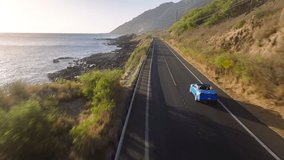 Beautiful nature of Hawaii tropical island in Pacific ocean. Blue convertible car driving on empty road by West coast on Oahu island. Aerial view of sport car with tourist. Road trip, summer adventure - Powered by Shutterstock - Get 15% off with code: PIKWIZARD15