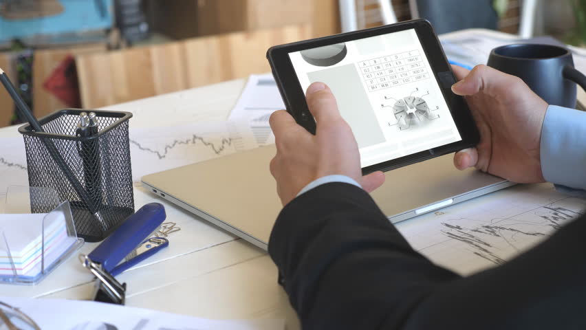 Young entrepreneur developing a business project and writing a reminder on note paper in office. Male hands of successful businessman analyzing statistical data information on a tablet pc | Shutterstock HD Video #1111919577