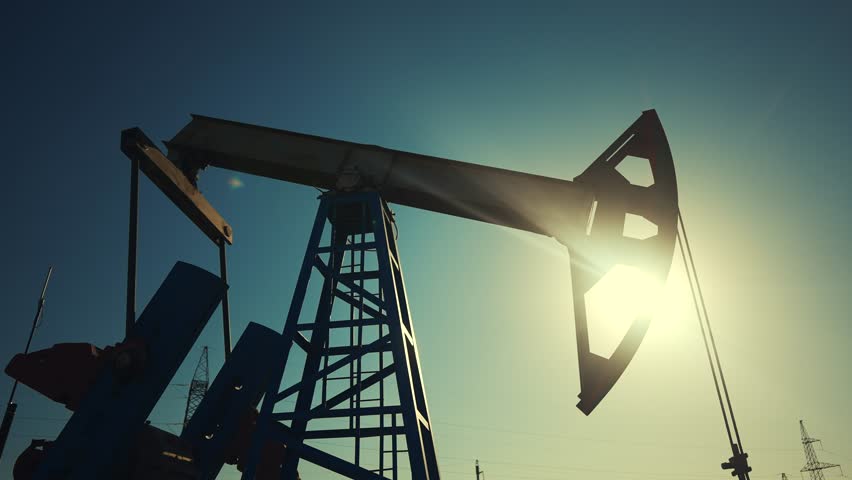 oil industry. silhouette of an oil pump extracts oil and gas from ground of the field. lifestyle business industry concept. pump pumps oil and gas at sunset. drill petroleum middle sunlight industry