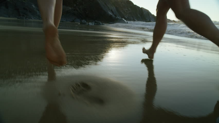 Two female friends run barefoot on empty beach, run into water and ocean surf. Cinematic shot of friendship and happiness, having fun with best friend during vacation | Shutterstock HD Video #1111923867