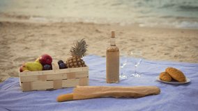 Wicker picnic basket with juicy fruits and wine, croissants and baguette bread on gray green tablecloth. Preparation for beach party at sunset - Powered by Shutterstock - Get 15% off with code: PIKWIZARD15