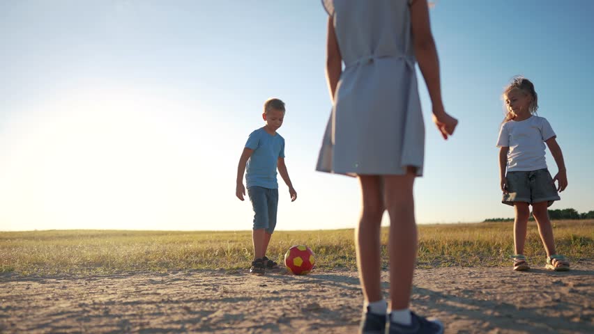 A group of small children playing football kicking the ball to each other. happy family childhood dream concept. little children playing with a ball in nature legs close-up lifestyle | Shutterstock HD Video #1111926691