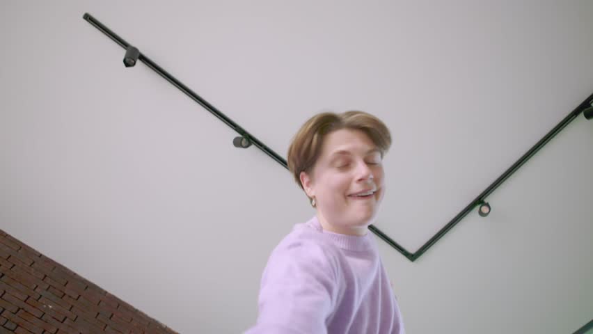 bottom close-up view of happy caucasian gender person dancing alone at home and jumping for joy