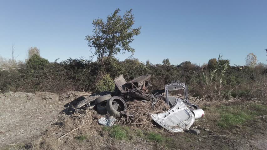Car destroyed and demolished illegally in the countryside by the mafia underworld - environmental pollution and crime against nature and people's health - illegally disposing of dangerous waste | Shutterstock HD Video #1111928071