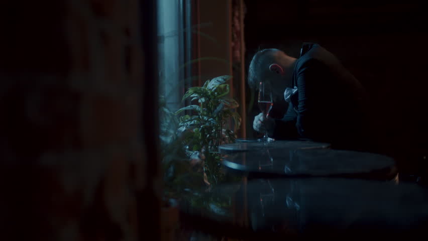 A man sitting alone at the table and drinking by the window | Shutterstock HD Video #1111928715