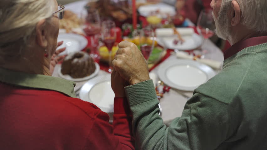 Family praying before eating tasty homemade food. Christmas dinner. Christmas decorations | Shutterstock HD Video #1111929157