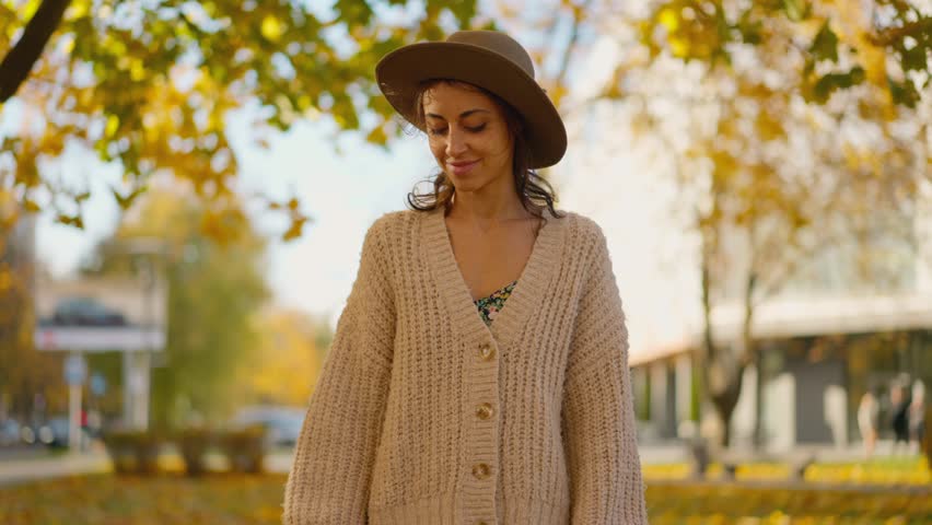 Portrait of an attractive brunette woman walking in the park at fall on a sunny day and smiling. The face of a happy beautiful woman in autumn outdoor. Slow-motion 4k footage | Shutterstock HD Video #1111932761