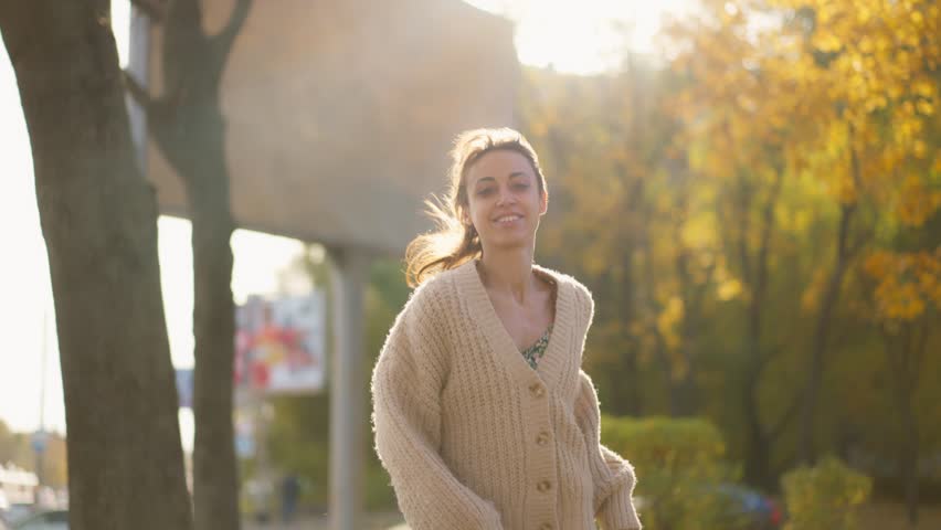 Stunning young brunette woman in autumn forest with yellow foliage against sunset sun with sunflare. stylish attractive girl walks in park at warm fall day. slow motion 4k footage | Shutterstock HD Video #1111932763