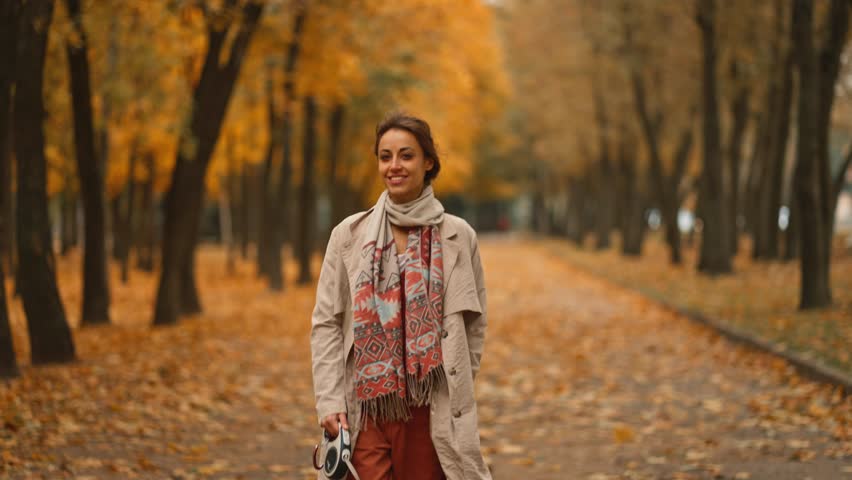 Slow motion: Adorable young elegant woman wearing coat walking with her cute welsh corgi dog in colorful golden autumn maple park in warm day, | Shutterstock HD Video #1111932771