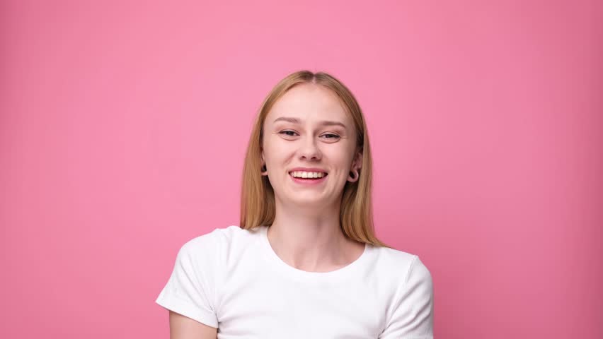 A cheerful girl throws silver glitter and cheer on a pink background. | Shutterstock HD Video #1111934105