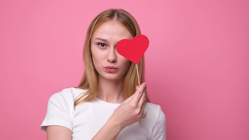 Portrait of attractive girl on pink background with red hearts for valentine's day. Concept of congratulations for holidays. | Shutterstock HD Video #1111934115