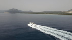 Aerial drone video of tropical paradise turquoise beach in Mediterranean Island of La Maddalena Archipelago, Costa Smeralda, Sardinia. Boat tracking