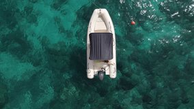 Aerial drone video of tropical paradise turquoise beach in Mediterranean Island of La Maddalena Archipelago, Costa Smeralda, Sardinia. Boat on water 