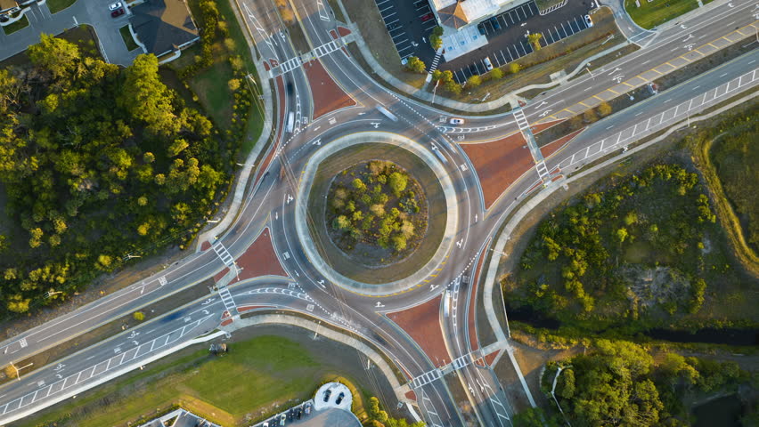 Aerial view of road roundabout intersection with fast moving heavy traffic. Timelapse of urban circular transportation crossroads Royalty-Free Stock Footage #1111937367