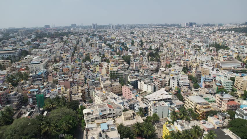 Bengaluru, the capital of Karnataka, is depicted in a dramatic aerial video as a busy residential neighborhood encircled by homes and apartment complexes. Horizontal-up video from a DJI drone Royalty-Free Stock Footage #1111937447