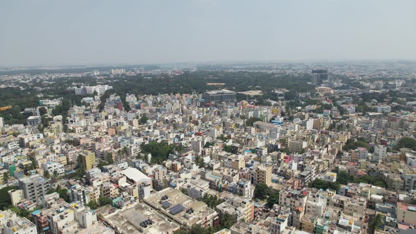 Dramatic aerial footage shows Bengaluru, the capital of Karnataka, as a bustling residential neighbourhood surrounded by single-family homes and apartment buildings. Video taken from a DJI drone. Royalty-Free Stock Footage #1111937449