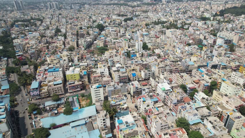 Bengaluru, the capital of Karnataka, is depicted in dramatic aerial footage as a busy residential neighbourhood encircled by single-family homes and apartment buildings. Royalty-Free Stock Footage #1111937591