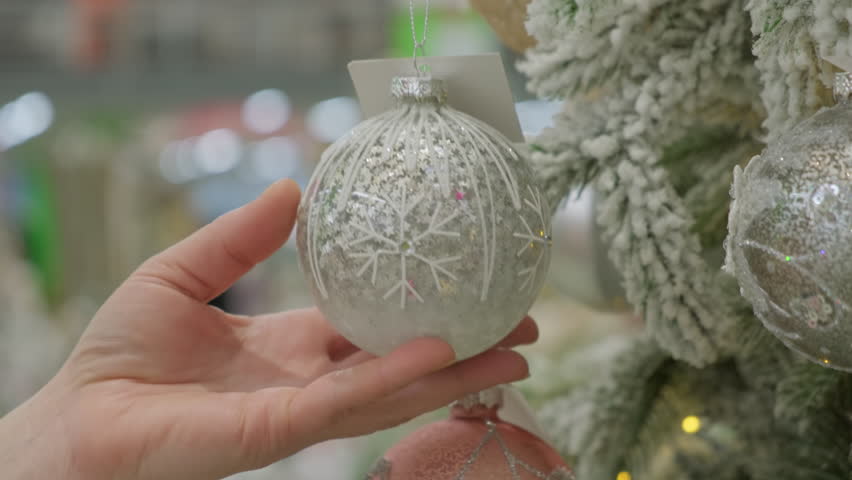 Woman's hand touching Christmas ball on decorated New Year tree close-up. | Shutterstock HD Video #1111939371