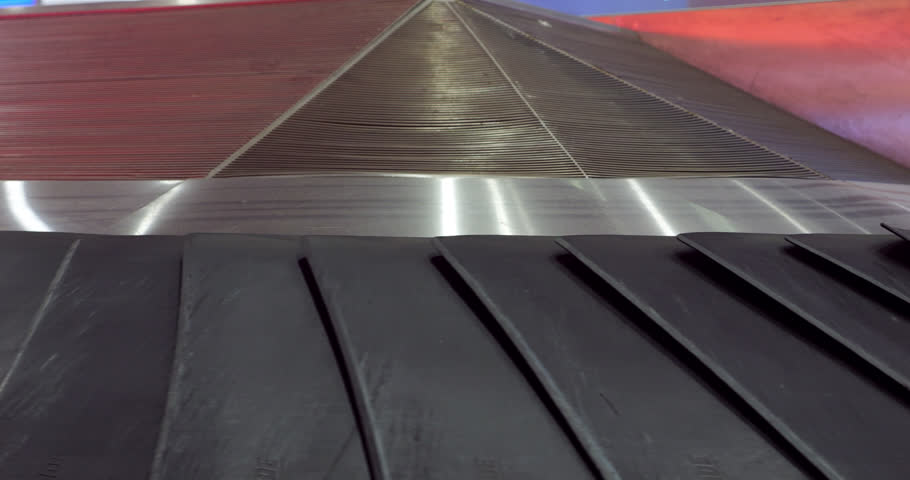 Close view on moving slates or leaves of empty luggage carousel at airport. Camera shows top part of conveyor belt, plates move to turning or curved area. Automated equipment at modern terminal | Shutterstock HD Video #1111940783