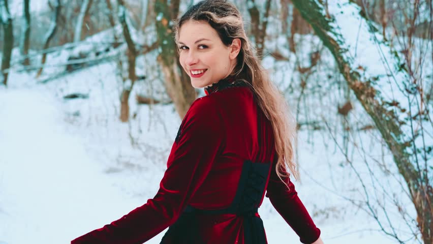 Fantasy happy woman smiling face running in deep forest dark tree covered frost, old style red train dress waving floats flies in wind. girl enjoys winter nature cold white snow. back rear view art 4k