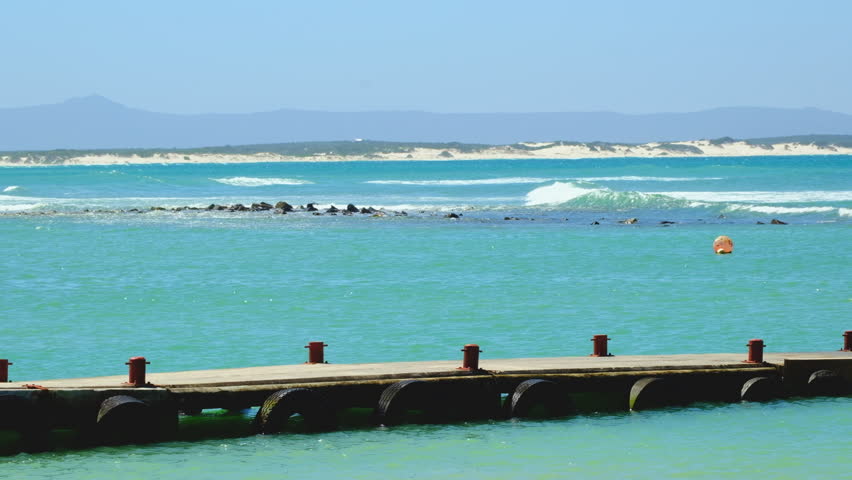 Scenic and pristine blue water and jetty along Struisbaai coastline, Overberg Royalty-Free Stock Footage #1111944519
