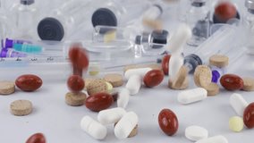 Falling Tablets and pills between glass bottles, ampoule and syringes. Slow motion. Medicine and healthy. Close up of capsules. - Powered by Shutterstock - Get 15% off with code: PIKWIZARD15