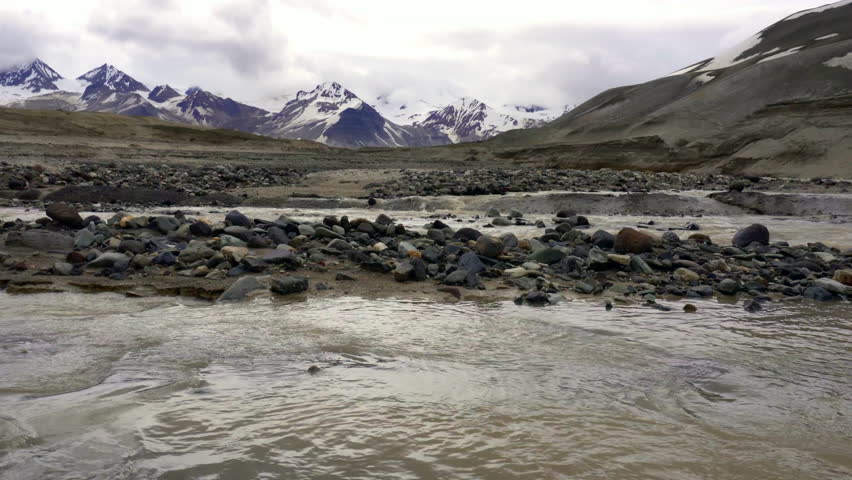 River flowing through The Valley of Ten Thousand Smokes in Katmai National Park and Preserve in Alaska. Valley between mountains is filled with ash flow from Novarupta eruption in 1912. Erosion of ash
