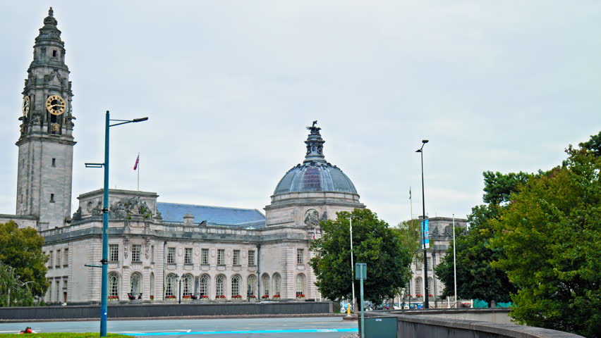 View of Cardiff City Hall municipal building with a clock tower and a Welsh dragon sculpture in Cardiff. The Edwardian baroque civic centre of local government in Wales. 