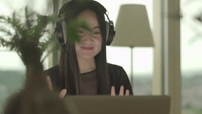 Female Person Listening to Music Video Wearing Earphones Looking at Laptop Screen