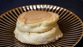 A video of pouring honey on soufflé pancakes.