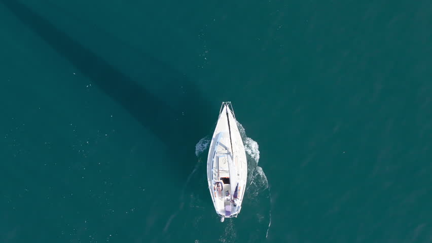 Top shot of sailboat floating in Pacific Ocean , Santa Barbara, California, USA. Birds eye view of yachts sailing in marina. Small boat surrounded blue deep waters of sea. Travel concept, 4k footage | Shutterstock HD Video #1111965749